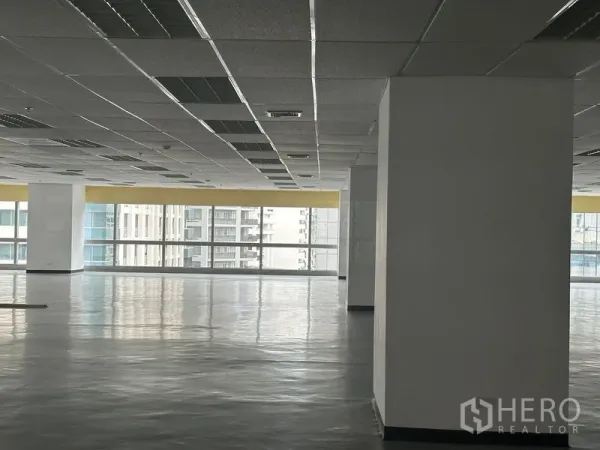 办公空间 出租 - 明亮办公角落，结构柱与整面窗墙，眺望周边高楼。