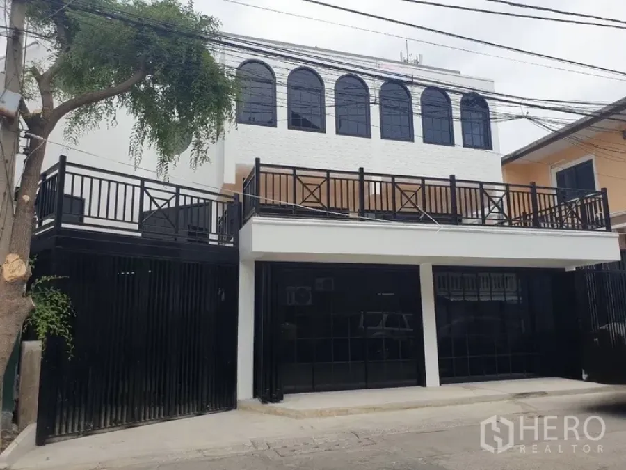 Home Office for rent or sale in Bang Na, Bangkok - Modern white two-storey home office facade with black gates and arched windows.