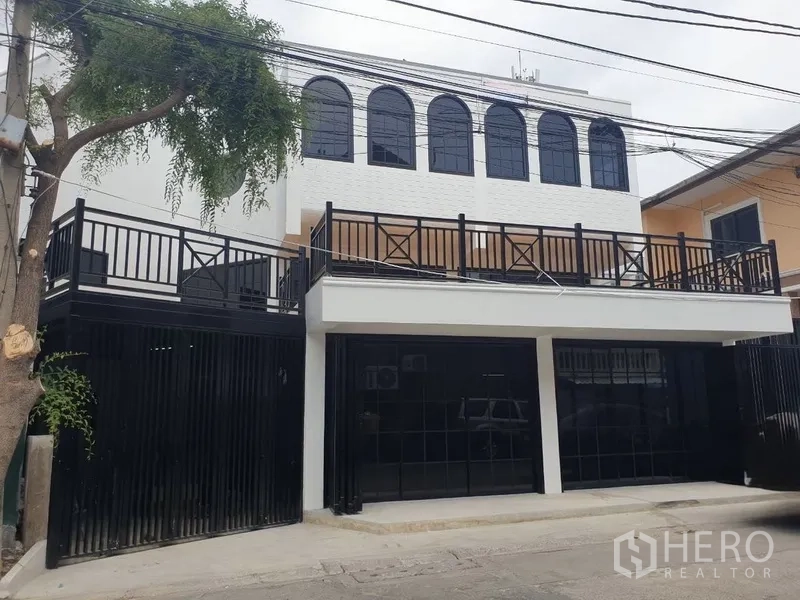 Home Office for rent or sale in Bang Na, Bangkok - Modern white two-storey home office facade with black gates and arched windows.