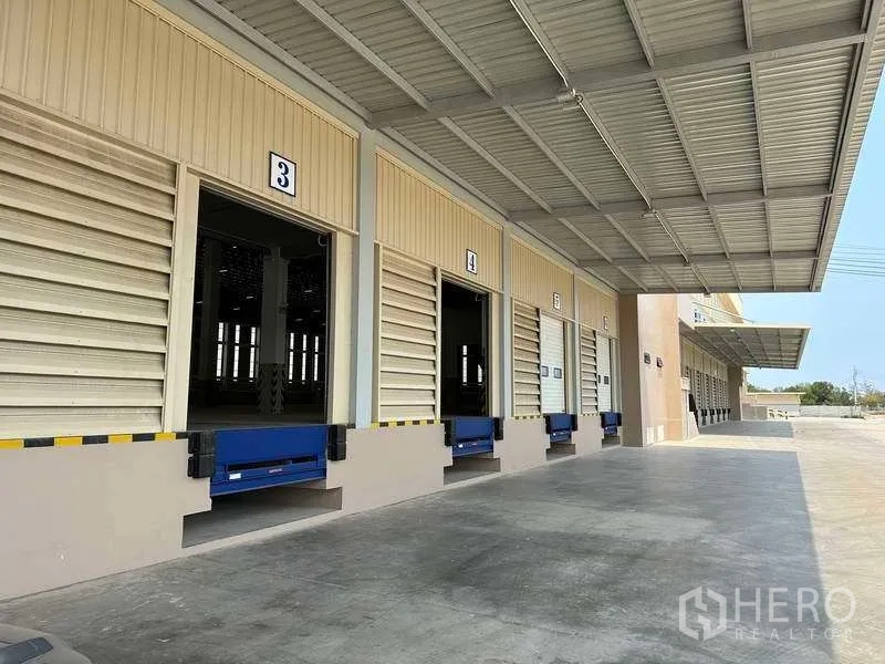 Factory for rent or sale in Samut Prakan - Covered loading bays with dock levelers and numbered doors at a modern factory.