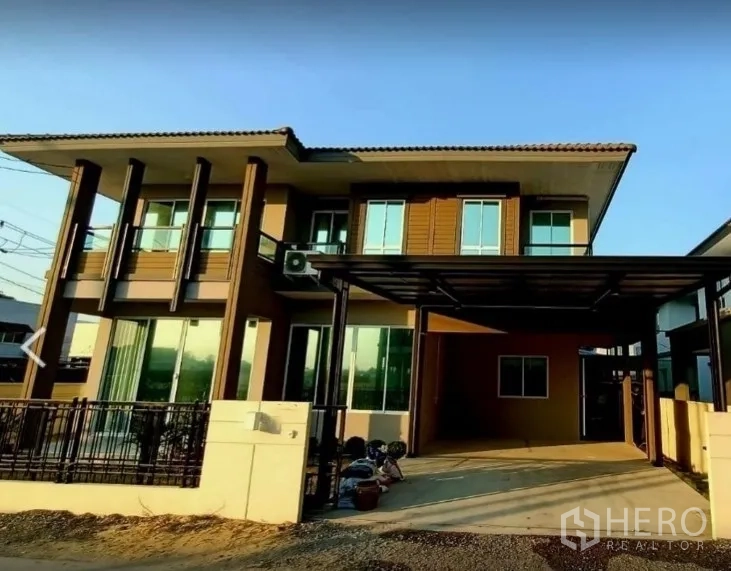 Detached House for rent or sale in Pathum Thani - Modern two-storey detached house exterior with covered carport and fenced front yard in Thanyaburi.