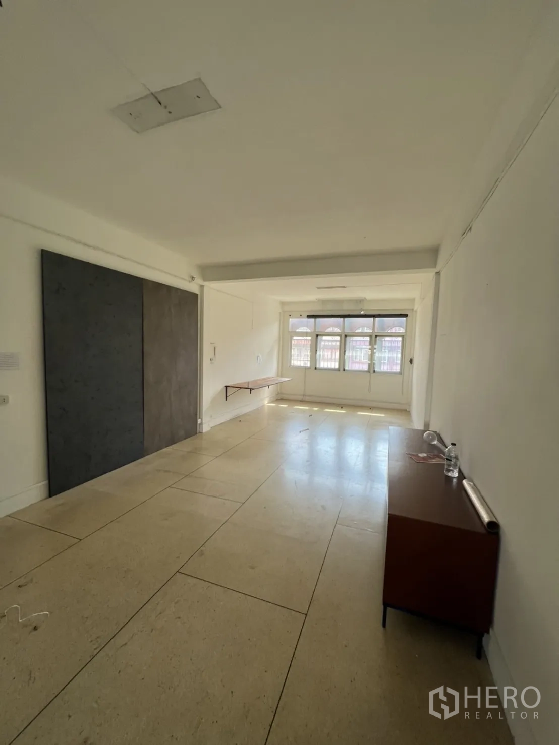 Shophouse for rent or sale in Watthana, Bangkok - Bright workspace with light flooring, floating shelf and front windows.