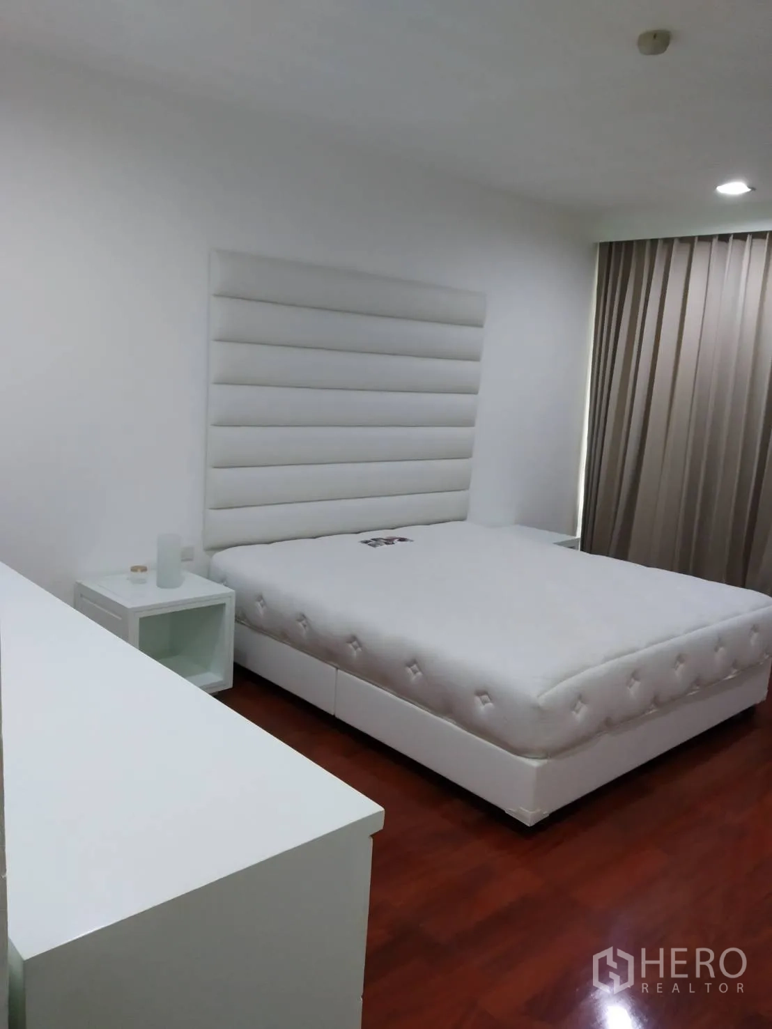 คอนโด ให้เช่าในPathum Wan, Bangkok - ห้องนอนรอง เตียงสีขาว โต๊ะข้างเตียง และม่านกันแสง