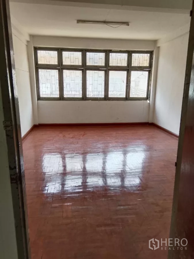 店屋 出租在Bang Rak, Bangkok - 宽敞房间，亮面木地板与整面格栅窗。