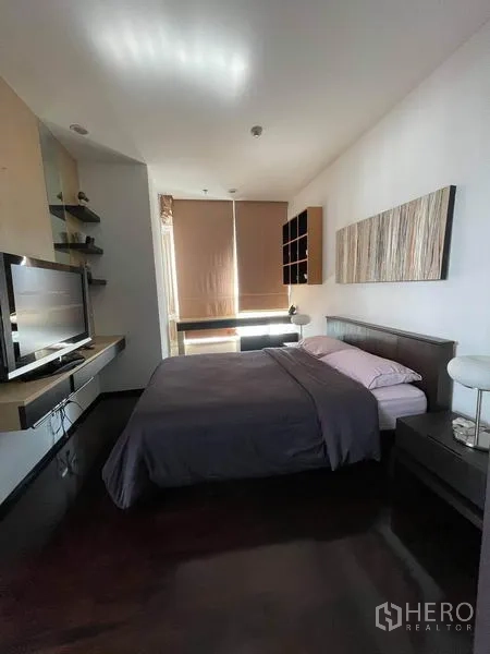 公寓 出租或出售在Watthana, Bangkok - 主卧配双人床、电视柜、遮光卷帘与墙面装饰画