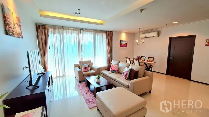อพาร์ทเมนท์ ให้เช่าในWatthana, Bangkok - ห้องนั่งเล่นสว่าง โซฟาเข้ามุมสีครีม ชั้นวางทีวี และหน้าต่างสูงจรดเพดาน