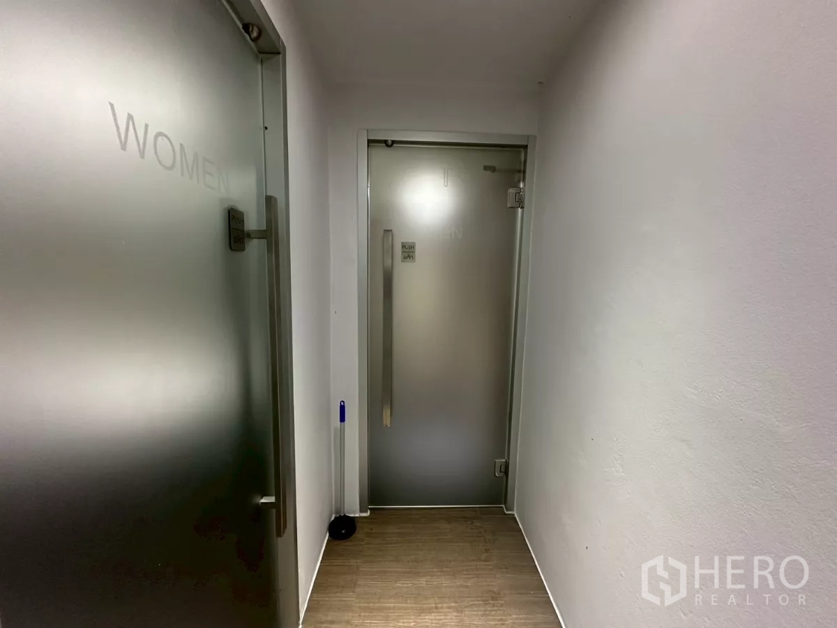 Office Space for rent in Khlong Toei, Bangkok - Hallway to gender-separate restrooms with frosted glass doors.
