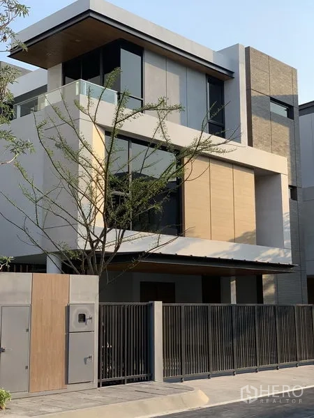 Detached House for sale in Yan Nawa, Bangkok - Close-up of a contemporary facade with large windows, balcony and metal gate.