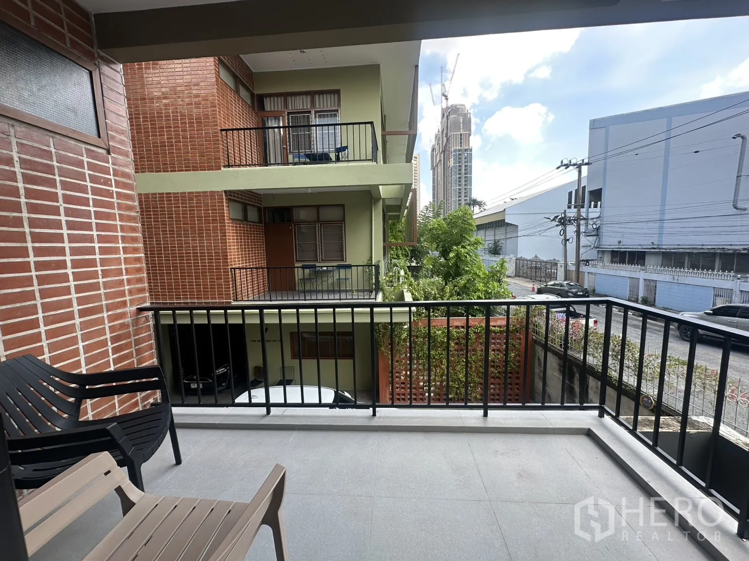 พื้นที่ขายของ for rent in Watthana, Bangkok - ระเบียงมีเก้าอี้ มองเห็นอาคารโลว์ไรส์และถนนด้านหน้า.