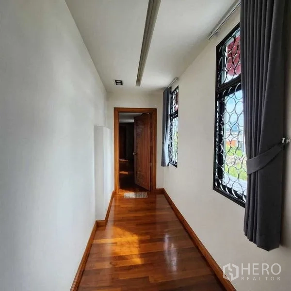 独立式住宅 出售在Phra Khanong, Bangkok - 采光走廊，木地板与带防护网的窗户