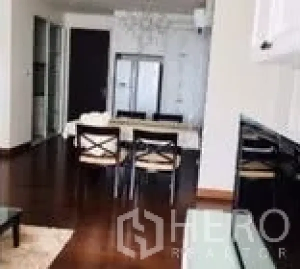 Condominium for rent in Watthana, Bangkok - Open-plan dining area with dark wood floors, chandelier feature and stainless refrigerator.