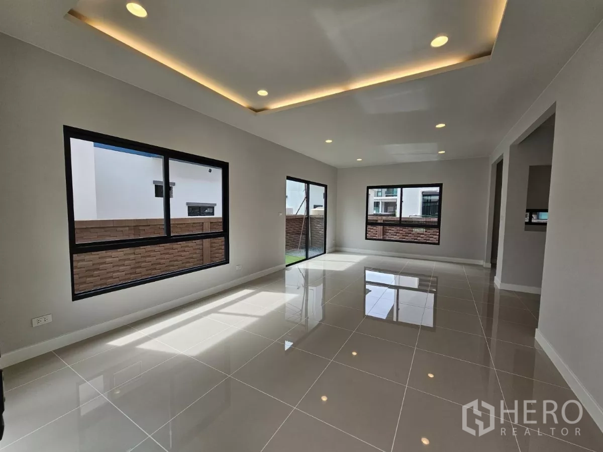 Detached House for sale in Lam Luk Ka, Pathum Thani - Open living and dining space with recessed lighting and garden views.