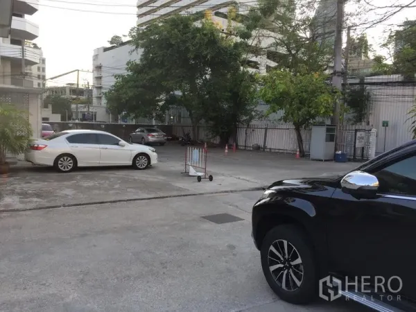 พื้นที่ขายปลีก ให้เช่าในKhlong Toei, Bangkok - ลานจอดรถสไตล์คอร์ทยาร์ดกว้าง มีต้นไม้ ประตูทางเข้า และคอนโดรายรอบ
