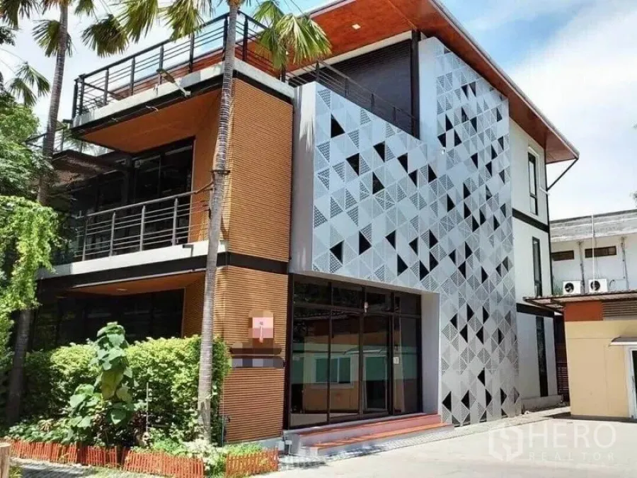 Office Space for rent in Bang Na, Bangkok - Modern three‑storey office exterior with patterned metal facade, balconies and palm trees.