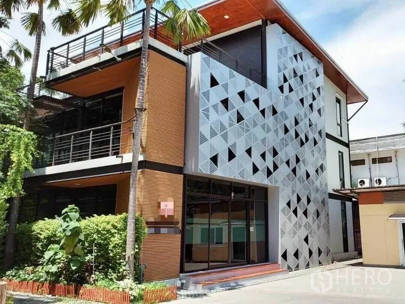 Office Space for rent in Bang Na, Bangkok - Modern three‑storey office exterior with patterned metal facade, balconies and palm trees.