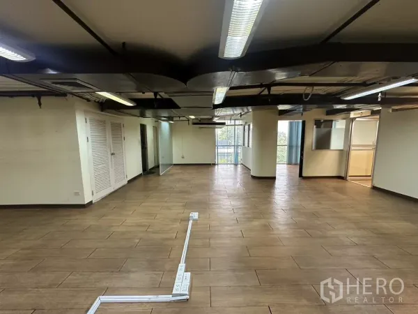 货栈 出租 - 通透走廊，地面走线槽、玻璃隔断与尽头自然采光。