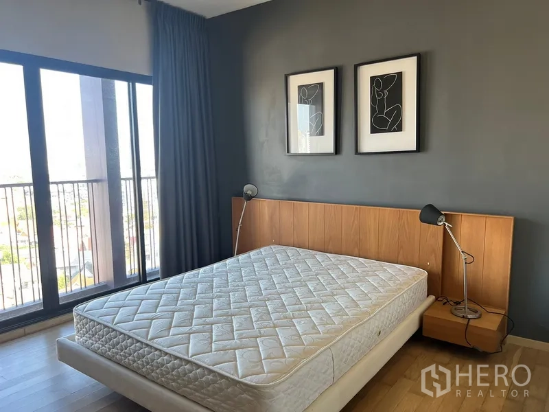 公寓 出租或出售在Watthana, Bangkok - 卧室带落地窗与阳台，木质床头板和两盏床头灯