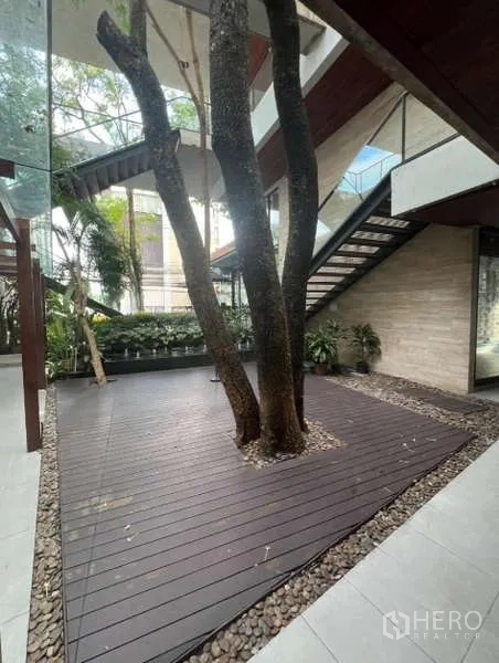 零售空间 出租在Watthana, Bangkok - 零售项目内，树木贯穿的木平台，配景观花坛与现代楼梯。