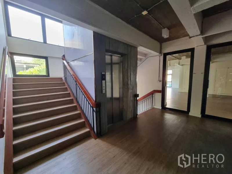 办公空间 出租在Phaya Thai, Bangkok - 楼内公共区，楼梯与电梯相邻，落地窗引入自然光