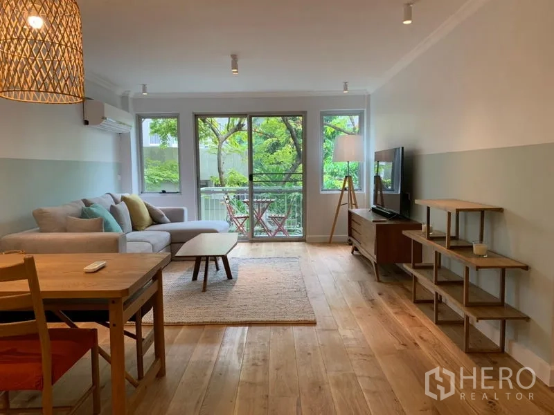 Condominium for sale in Watthana, Bangkok - Open living and dining room with balcony access and abundant natural light.