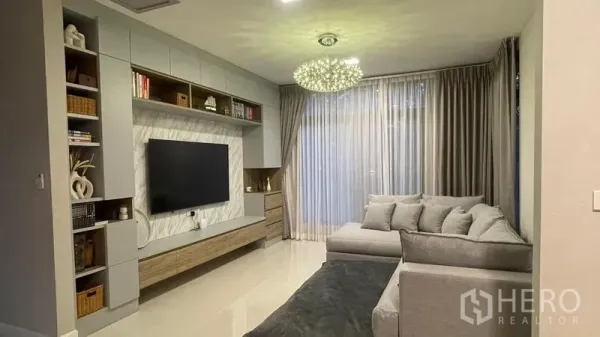 独立式住宅 出租在Bang Phli, Samut Prakan - 明亮客厅，内置电视墙、转角沙发与吊灯
