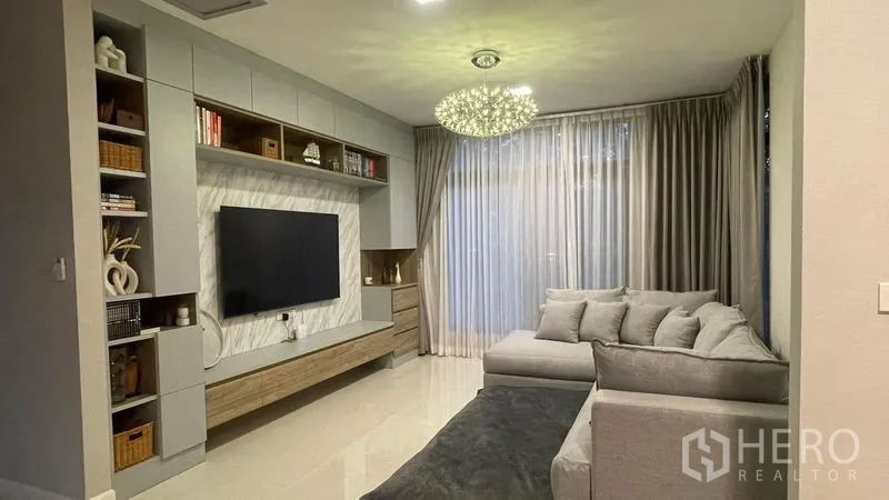 独立式住宅 出租在Bang Phli, Samut Prakan - 明亮客厅，内置电视墙、转角沙发与吊灯