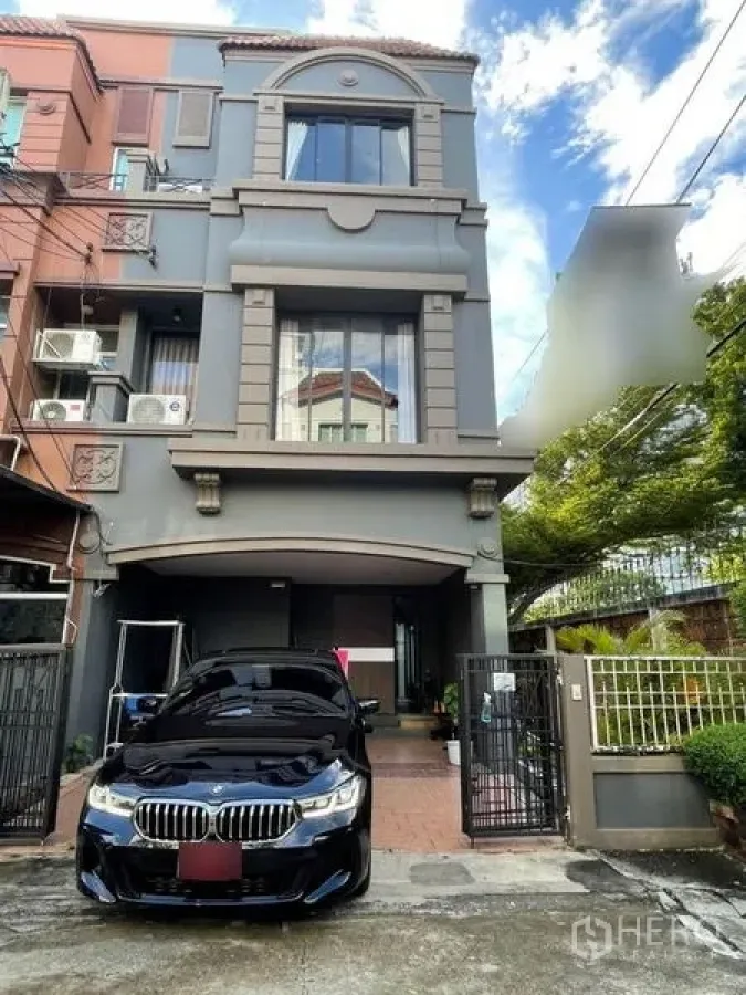 Townhouse for sale in Bang Phli, Samut Prakan - Three-storey townhouse exterior with gated entrance and covered carport.