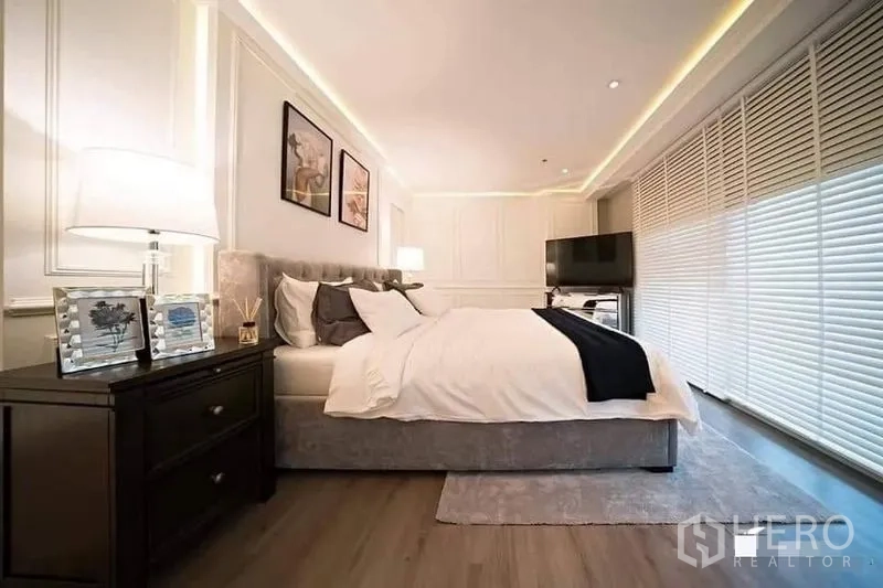 公寓 出租或出售在Watthana, Bangkok - 宽敞主卧，床头柜、大窗百叶与电视角落一应俱全。