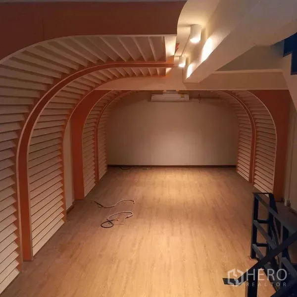 Shophouse for rent in Watthana, Bangkok - Open-plan shop space with arched wall displays and warm lighting