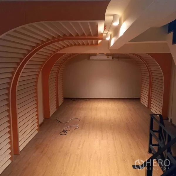 Shophouse for rent in Watthana, Bangkok - Open-plan shop space with arched wall displays and warm lighting