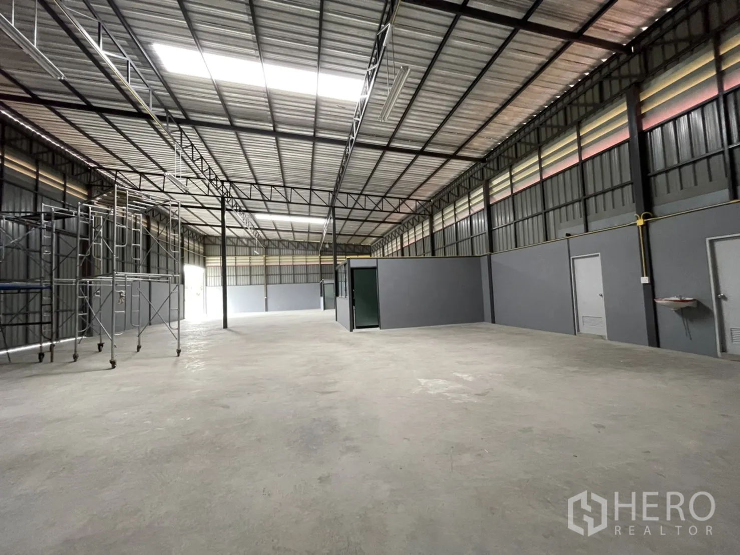 Factory for rent in Khlong Luang, Pathum Thani - Open-plan industrial hall with reinforced concrete floor and multiple service doors.