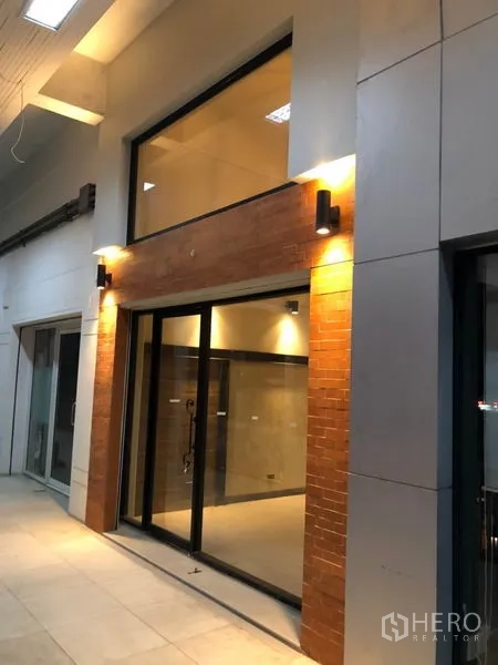 Retail Space for rent in Watthana, Bangkok - Retail shop entrance with sliding glass doors, brick facade and canopy lighting.