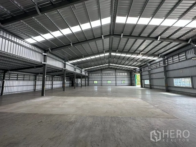 货栈 出租在Mueang Nonthaburi, Nonthaburi - 对称型仓库空间，侧边类似夹层的平台与远端卷帘门。