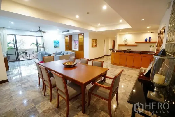 Apartment for rent in Watthana, Bangkok - Spacious open-plan living and dining area with marble floors, recessed lighting and balcony access near Phrom Phong.