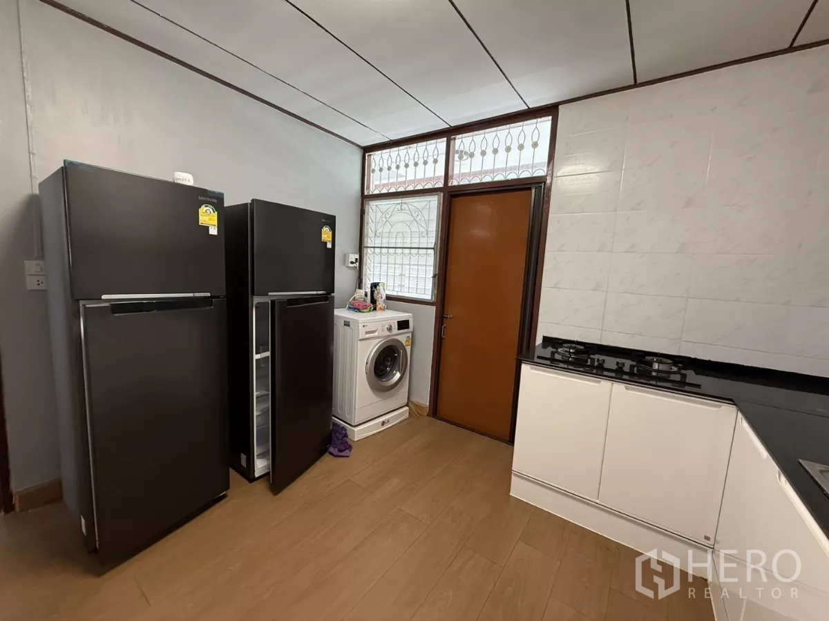 Detached House for rent in Phra Khanong, Bangkok - Kitchen corner with two refrigerators, washing machine and gas hob.