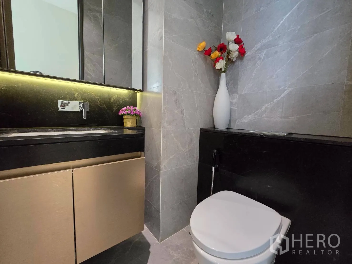 公寓 for rent in Pathum Wan, Bangkok - 浴室采用灰色大理石墙面，背光洗手台与坐便器。