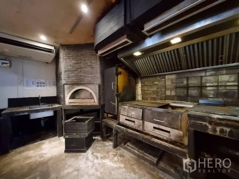 Detached House for rent in Khlong Toei, Bangkok - Close-up of brick pizza oven, grills and ventilation hoods in the kitchen.