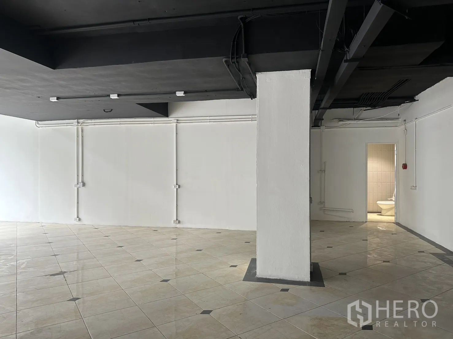 Retail Space for rent in Pathum Wan, Bangkok - Pillared zone of the shop with a doorway leading to a restroom.