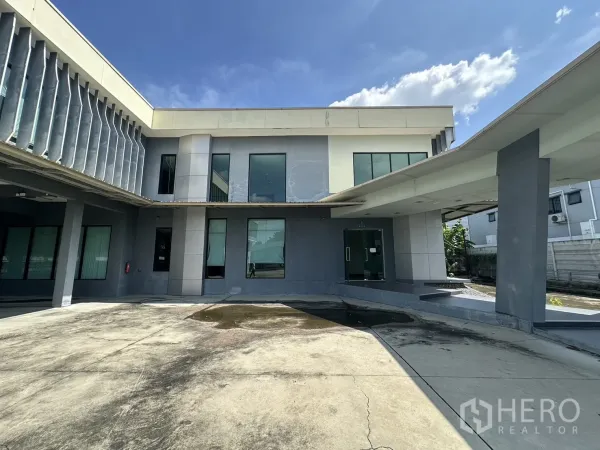带办公室的家 出租在Prawet, Bangkok - 办公楼雨棚入口与玻璃门，连接混凝土车道。