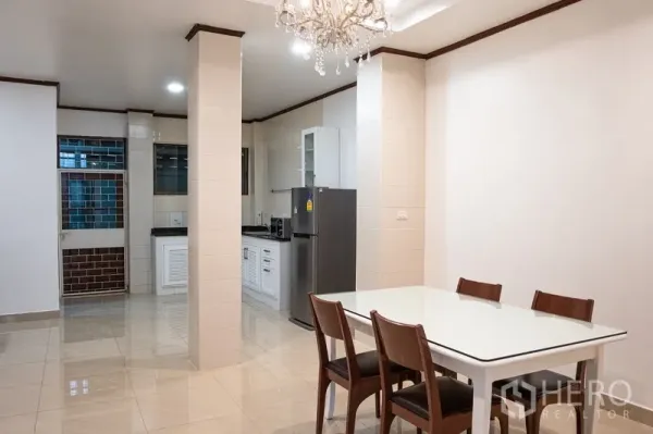 Home Office for rent in Khlong Toei, Bangkok - Bright dining area with chandelier beside a fitted kitchen.