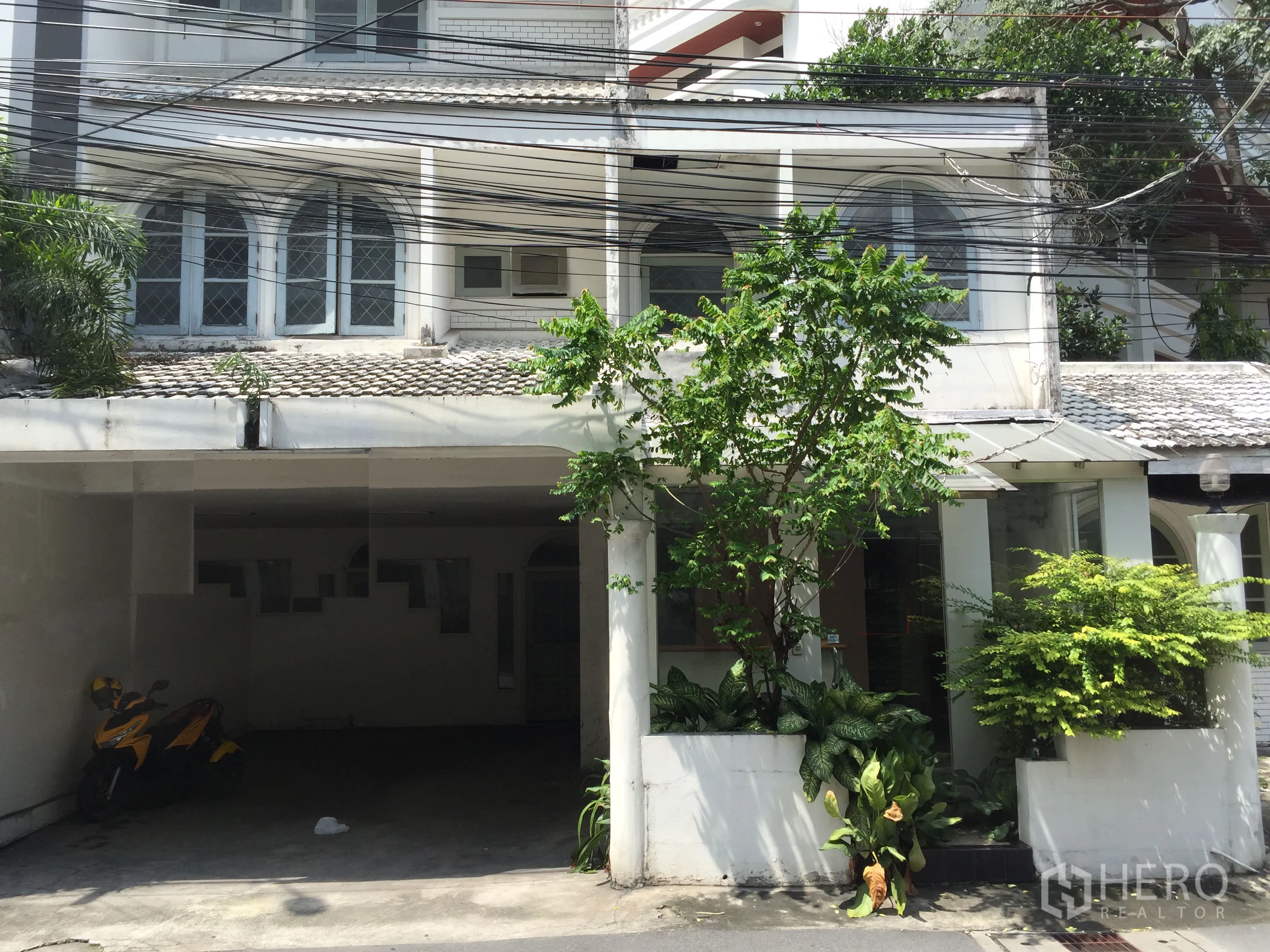 พื้นที่ขายปลีก ให้เช่าในWatthana, Bangkok - อาคารหน้าติดถนนสีขาวทรงโลว์ไรส์ หน้าต่างโค้ง มีที่จอดรถในร่มและสวนกระถาง เหมาะทำร้านค้า ใกล้ BTS ทองหล่อ.