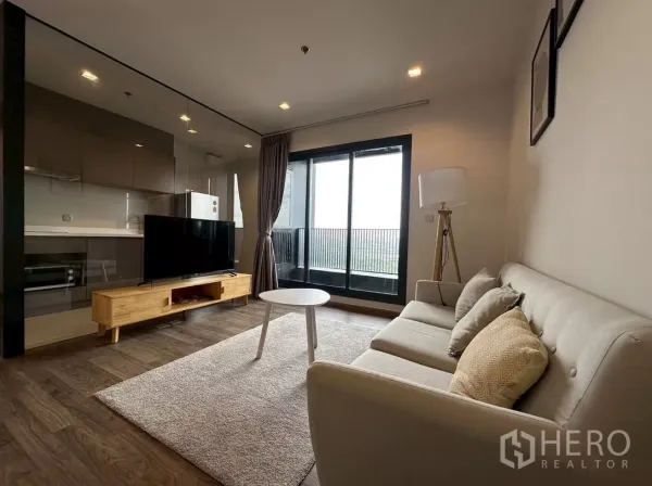 公寓 出租在Chatuchak, Bangkok - Life Ladprao Valley 客厅，配沙发、电视柜与通阳台的落地玻璃门。