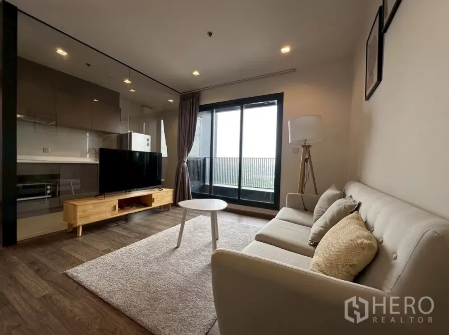 公寓 出租在Chatuchak, Bangkok - Life Ladprao Valley 客厅，配沙发、电视柜与通阳台的落地玻璃门。