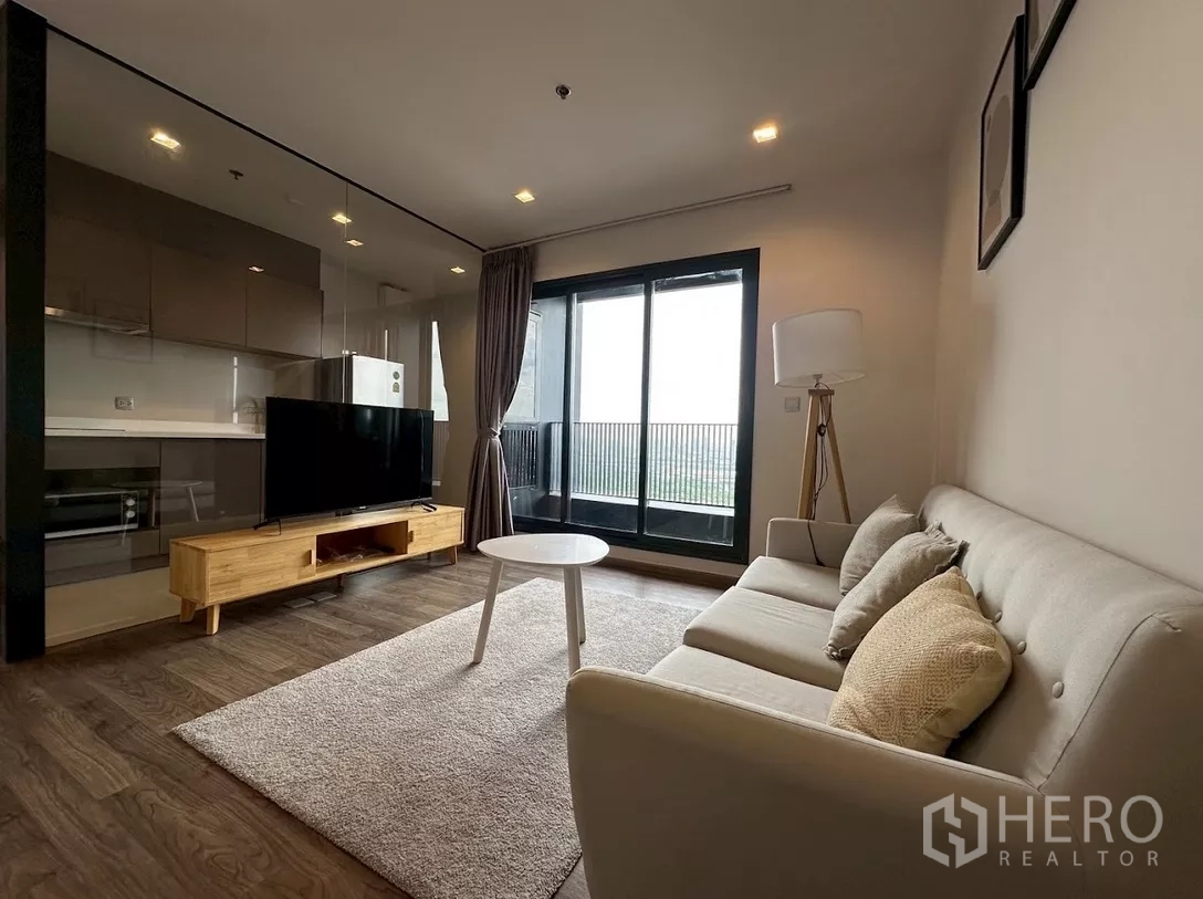 公寓 出租在Chatuchak, Bangkok - Life Ladprao Valley 客厅，配沙发、电视柜与通阳台的落地玻璃门。