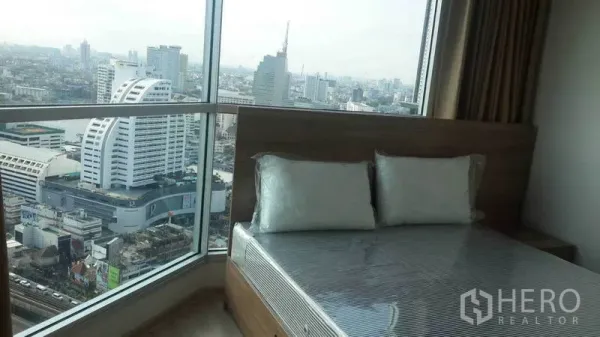 Condominium for rent in Sathon, Bangkok - Corner bedroom with floor-to-ceiling windows and skyline views of Bangkok.