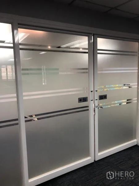 Office Space for rent - Frosted glass double doors with horizontal stripes inside a modern office interior.