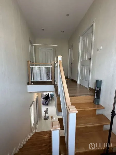 Detached House for sale in Sai Mai, Bangkok - Wooden staircase leading to the upper landing with bedroom doors.