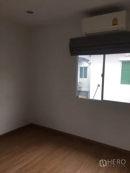 Detached House for rent in Suan Luang, Bangkok - Bedroom with window and wall-mounted air conditioner.