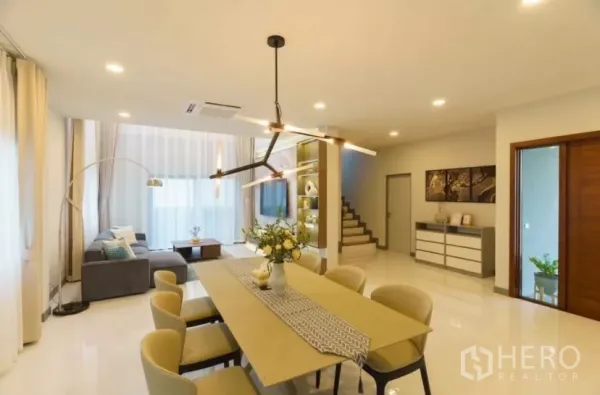 独立式住宅 出租或出售在Bang Phli, Samut Prakan - 开放式客餐厅，长餐桌、设计吊灯与楼梯。