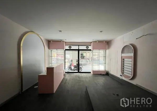 Shophouse for rent in Watthana, Bangkok - Interior view toward the entrance showing twin display windows and central raised flooring.